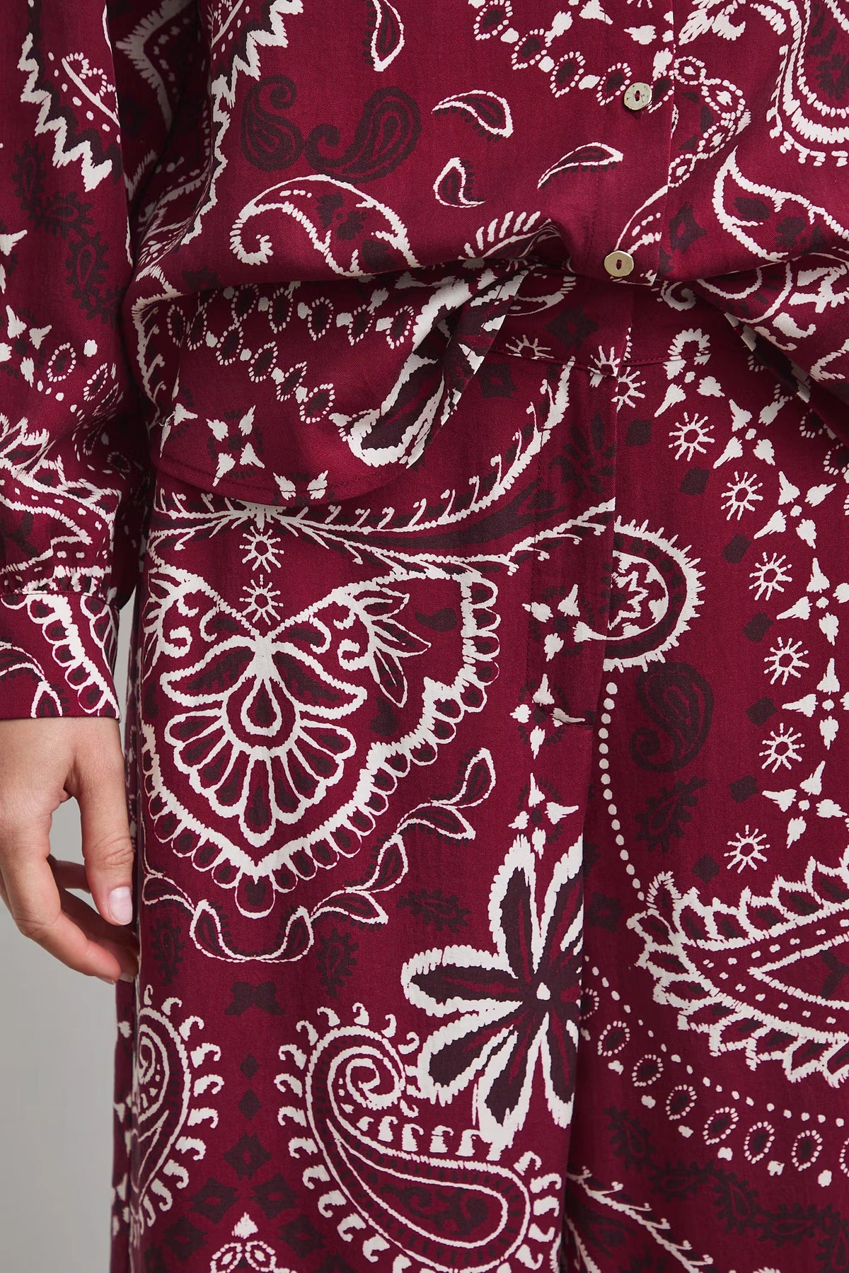 Damesbroek met wijde pijpen en een opvallende paisleyprint in bordeauxrood en wi